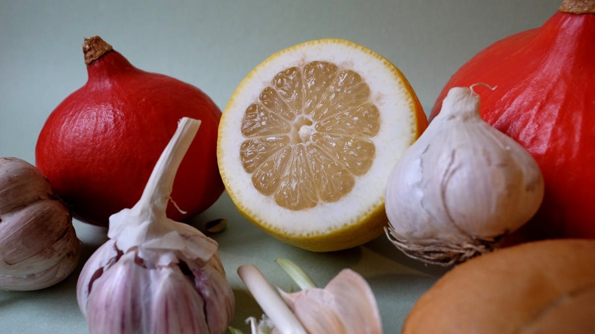 Vibrant still life of lemons, garlic, and red squash showcasing fresh produce.